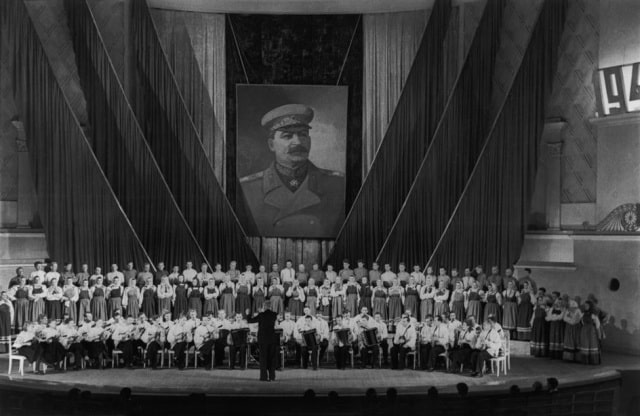 Hall de Tchaikovsky, coro ucraniano cantando canciones tradicionales ante un cuadro de Stalin 